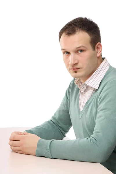 Een jonge man zittend aan tafel — Stockfoto