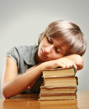 kitap yığını üzerinde uyuyan genç kadın