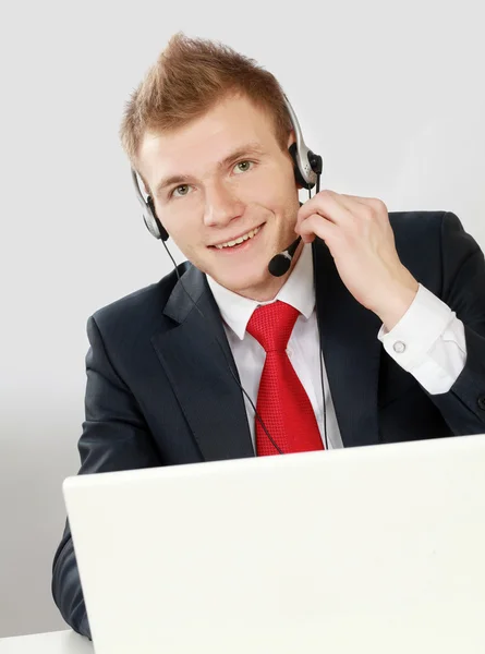 Een portret van een jonge man aan het werk op een laptop — Stockfoto