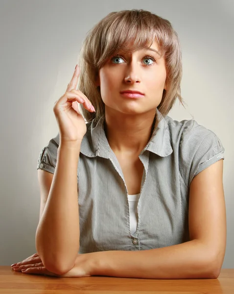 Una giovane donna pensierosa alla scrivania — Foto Stock