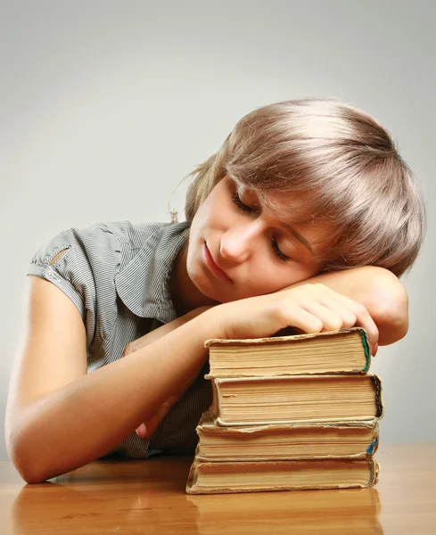 Giovane donna che dorme su pile di libri — Foto Stock