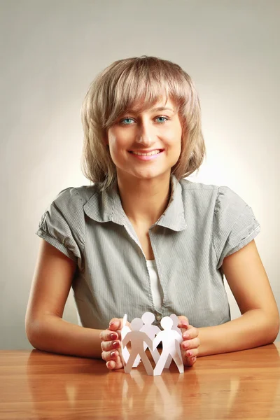 A young woman holding paper people — Stock Photo, Image