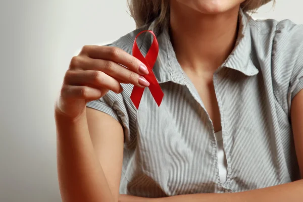 Una mujer sosteniendo ayudas cinta roja — Foto de Stock