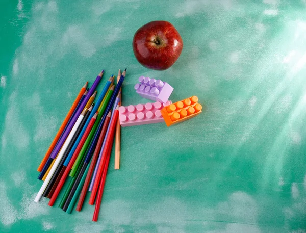 Red apple, pencils, construction set — Stock Photo, Image