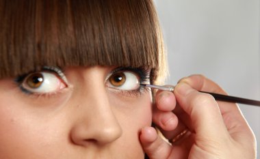 Makyaj yapan genç bir kadın.