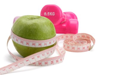 bir elma, bir ölçüm bandı ve dumbbell