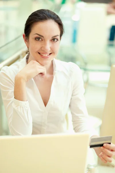 Glückliche Frau sitzt auf dem Schreibtisch — Stockfoto