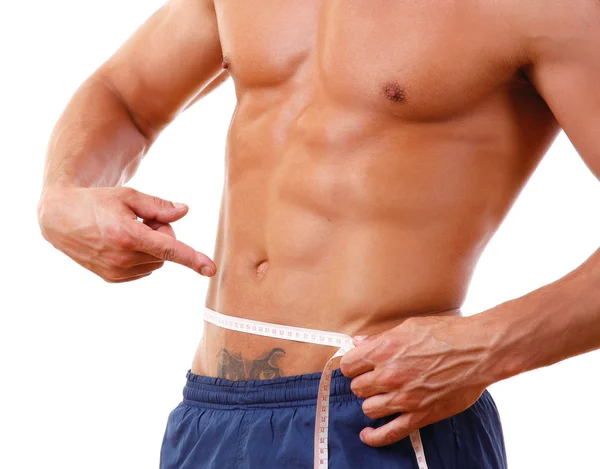 Man med en muskulös kropp mäta hans abs — Stockfoto