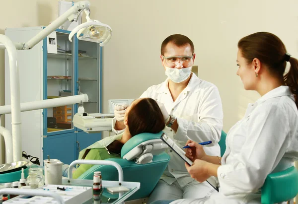 Mujer joven con dentista en una cirugía dental — Foto de Stock