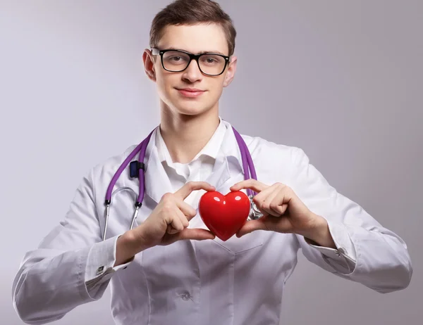 Médico masculino com estetoscópio segurando coração — Fotografia de Stock