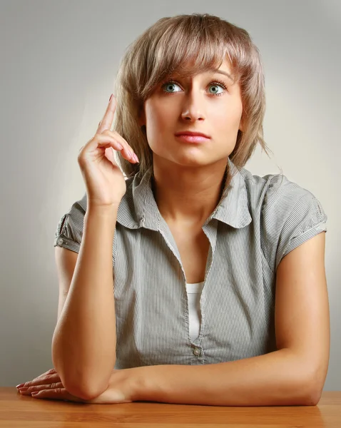 Una joven pensativa sentada en el escritorio — Foto de Stock