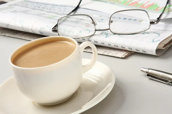 Una taza de café, vasos y un bolígrafo sobre papeles — Foto de Stock