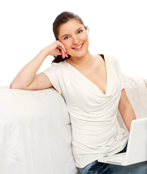 Young lady sitting on couch using laptop — Stock Photo, Image