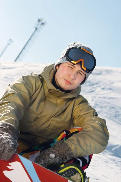 Snowboarder sentado em uma pista de esqui — Fotografia de Stock