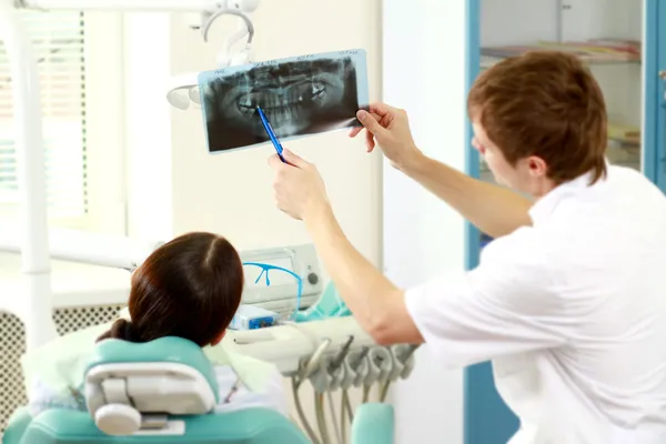 En tandläkare som innehar en röntgenbild — Stockfoto