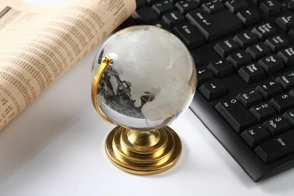 The earth near laptop computer and newspaper — Stock Photo, Image