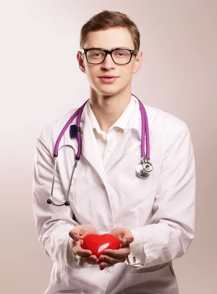 Мужчина-врач со стетоскопом, держащий сердце — стоковое фото