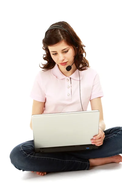 Een jong meisje, zittend op de vloer met een laptop — Stockfoto