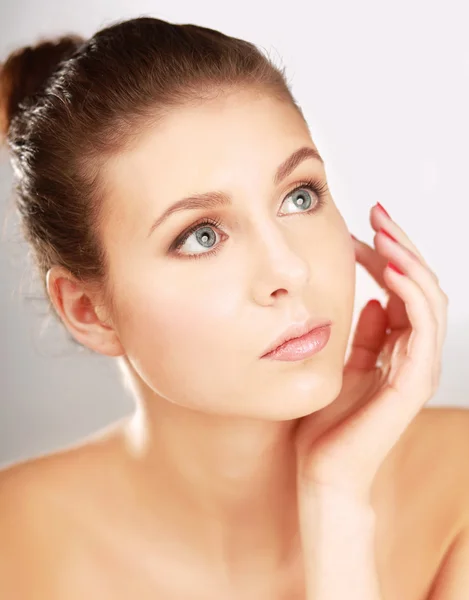 A beautiful young woman touching her face — Stock Photo, Image