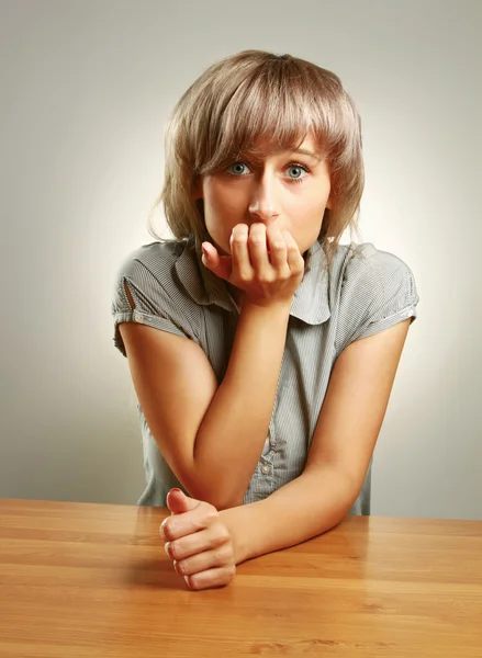 Молодая девушка сидит за столом — стоковое фото