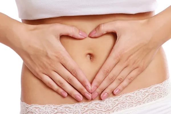 Hands on a female belly — Stock Photo, Image