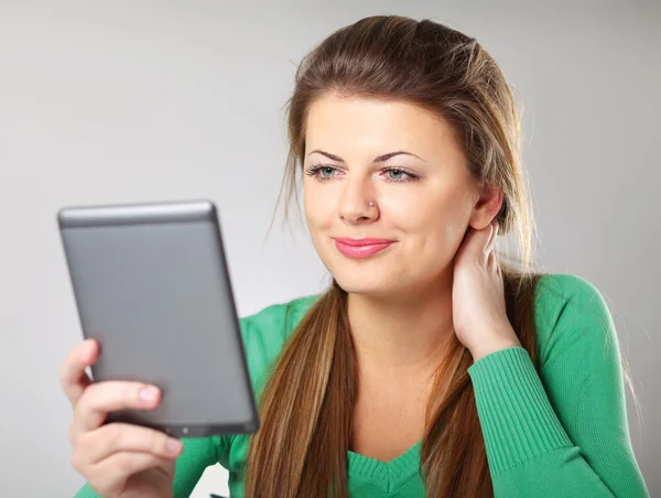 Mujer sentada en el escritorio y sosteniendo la computadora de mesa plana — Foto de Stock