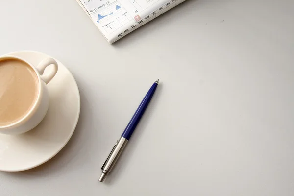 Una taza de café y un bolígrafo en la mesa — Foto de Stock