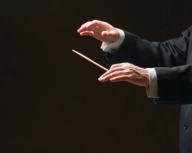Concert conductor's hands with a baton clipart
