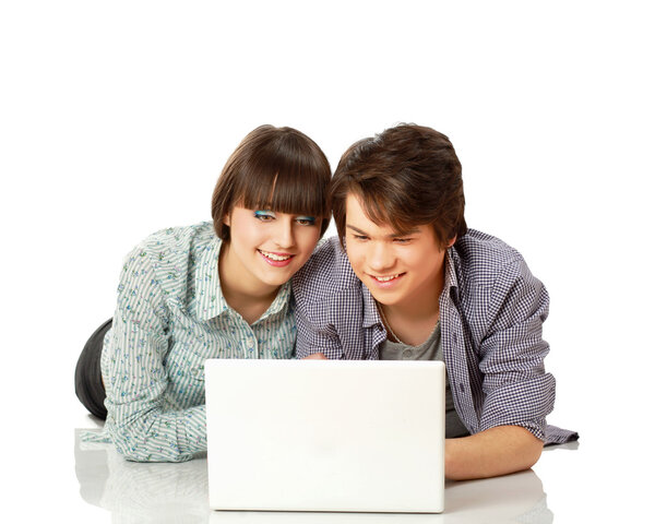 Couple lying on the floor behind a laptop