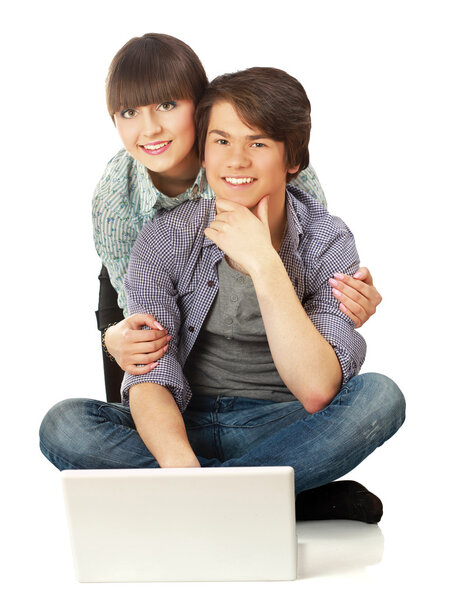 Couple sitting on the floor behind a laptop
