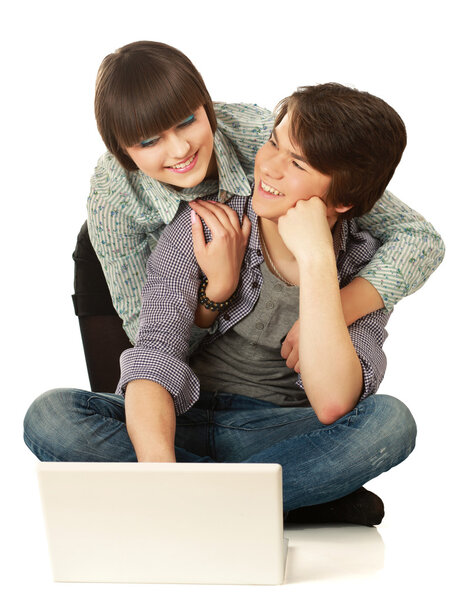 Couple sitting on the floor behind a laptop