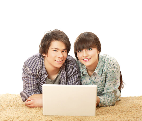 A couple lying on the floor behind a laptop
