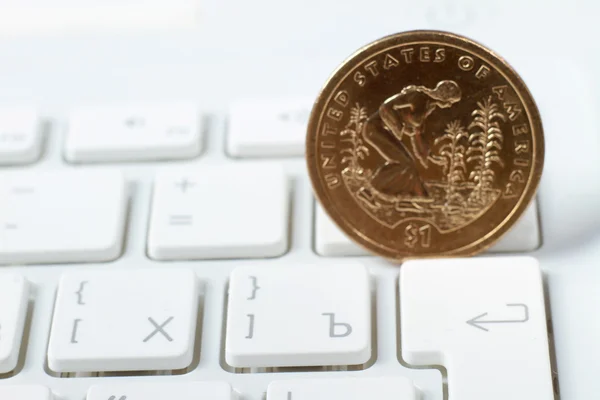 A coin on a laptop keyboard — Stock Photo, Image