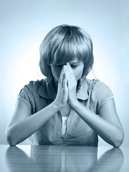 A young upset woman sitting at the desk — Stock Photo, Image