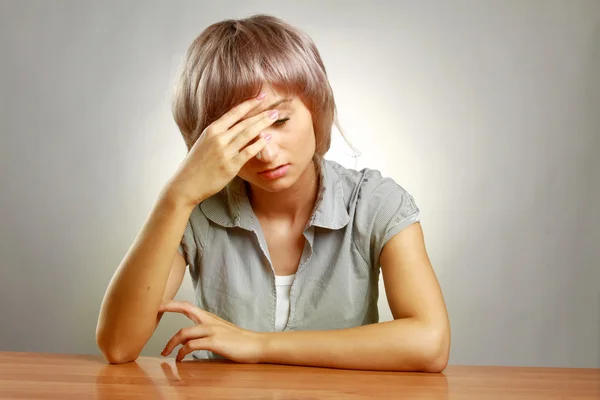 Een jonge moe vrouw zitten aan de balie — Stockfoto