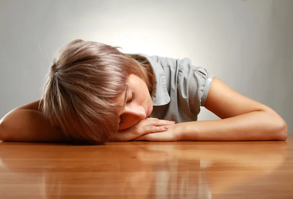 Eine müde Frau schläft auf dem Schreibtisch — Stockfoto