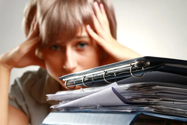 A tired young woman sitting at the desk — Stock Photo, Image