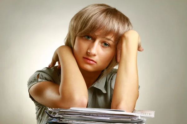 Eine müde junge Frau sitzt am Schreibtisch — Stockfoto