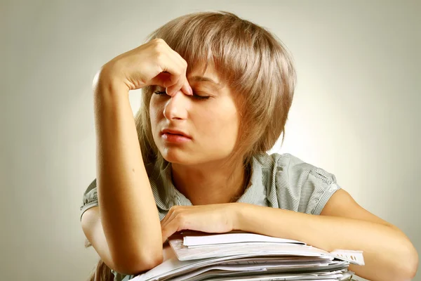 A tired young woman sitting at the desk — Stock Photo, Image