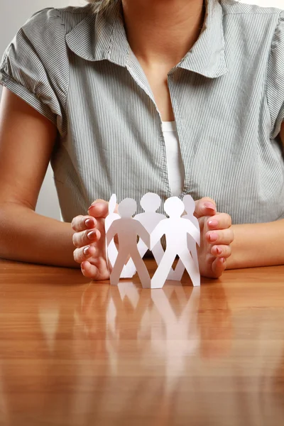Female hands taking care of paper people — Stock Photo, Image