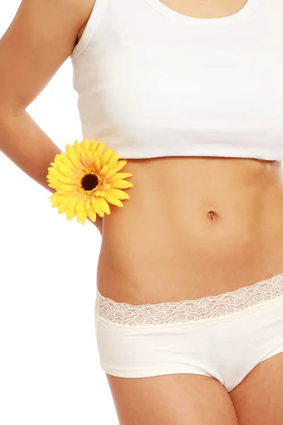 Uma parte de um corpo feminino com uma flor de gerbera — Fotografia de Stock