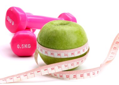 bir elma, bir ölçüm bandı ve dumbbell