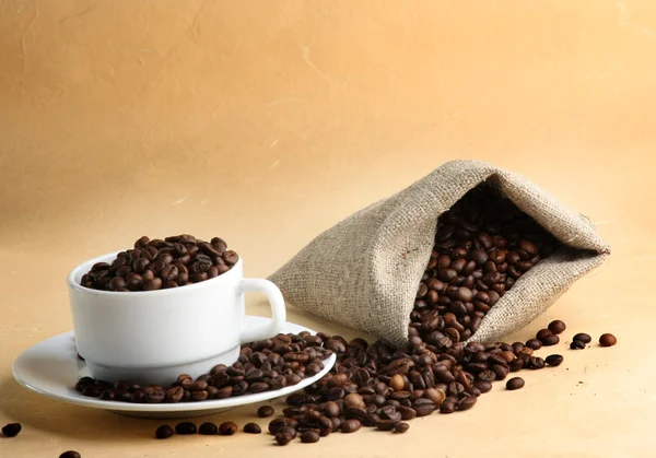 Un saco de granos de café y una taza —  Fotos de Stock