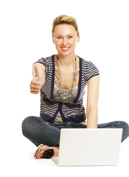 Ein junges Mädchen mit einem Laptop auf dem Boden sitzend — Stockfoto