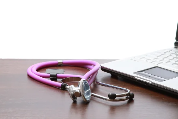 Een medische stethoscoop in de buurt van een laptop — Stockfoto