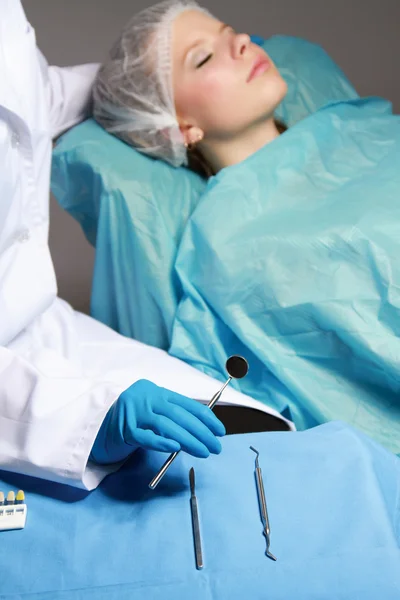 Médico con instrumentos y paciente mentiroso — Foto de Stock