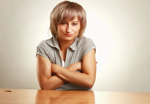 A young frightened woman sitting at the desk — Stock Photo, Image