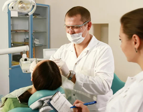 Jonge vrouw met tandarts in een tandheelkundige chirurgie. gezondheidszorg, geneeskunde. — Stockfoto