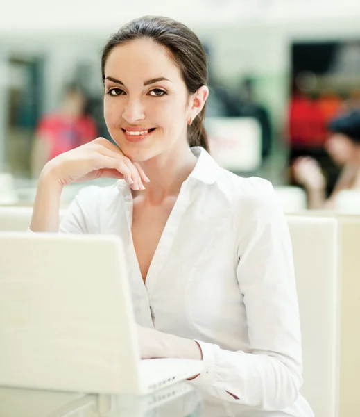 Schöne glückliche Frau sitzt mit Laptop. — Stockfoto