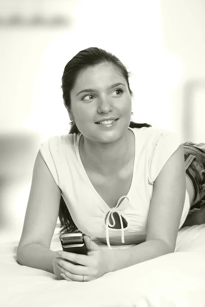 A woman with a mobile phone looking to the side — Stock Photo, Image